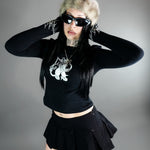 Chaos Longsleeve Tee - Thumb Holes & Silver Embroidery styled with black mini skirt and fur hat. Features cropped fit and gothic silver chest design.
