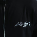 Detail of silver Gamble chest embroidery, textured black fabric and zip.