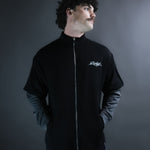 Ace Track Longsleeve front studio portrait showing silver zip, Gamble chest logo and layered charcoal sleeves.