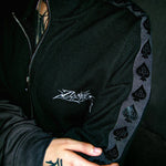 Close-up of Ace Track embroidered chest logo and tonal spade tape down the shoulder.