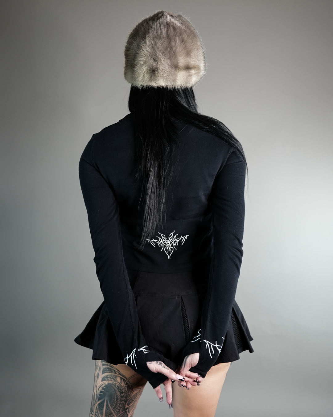 Chaos Longsleeve Tee in black with silver embroidery on sleeves and lower back, featuring thumb holes and a cropped fit for womens  wear.